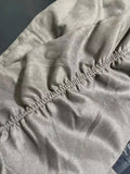 Close-up of a gray fabric with texture and stitching details.
